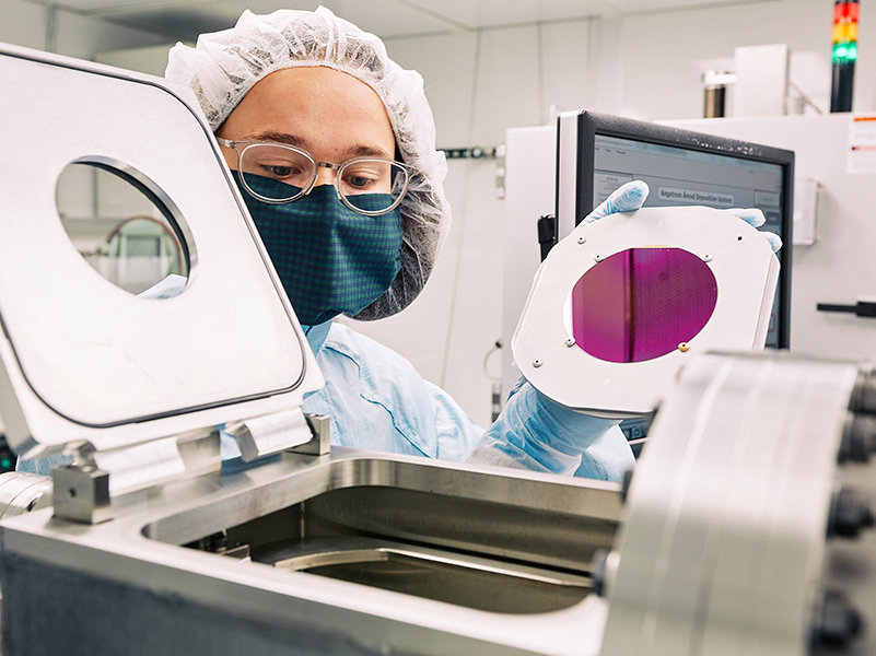 Female student lab worker using lab equipment