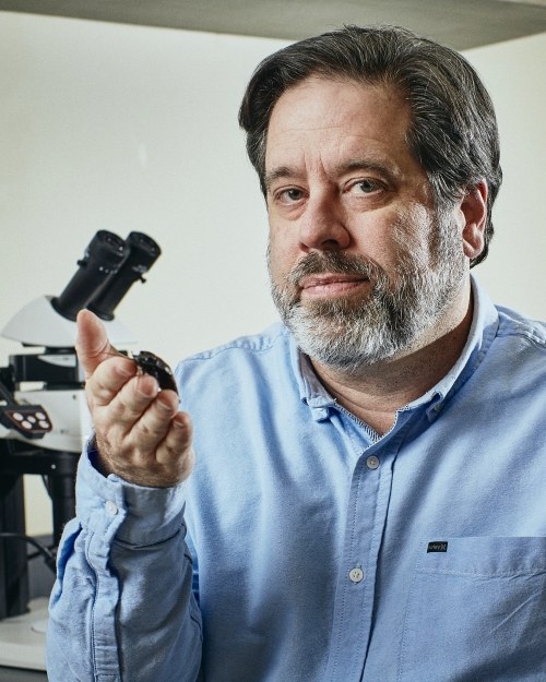 Photo of Bob Peterson holding a beetle